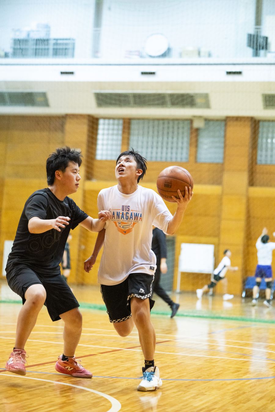 体育館でバスケットボールに取り組む生徒